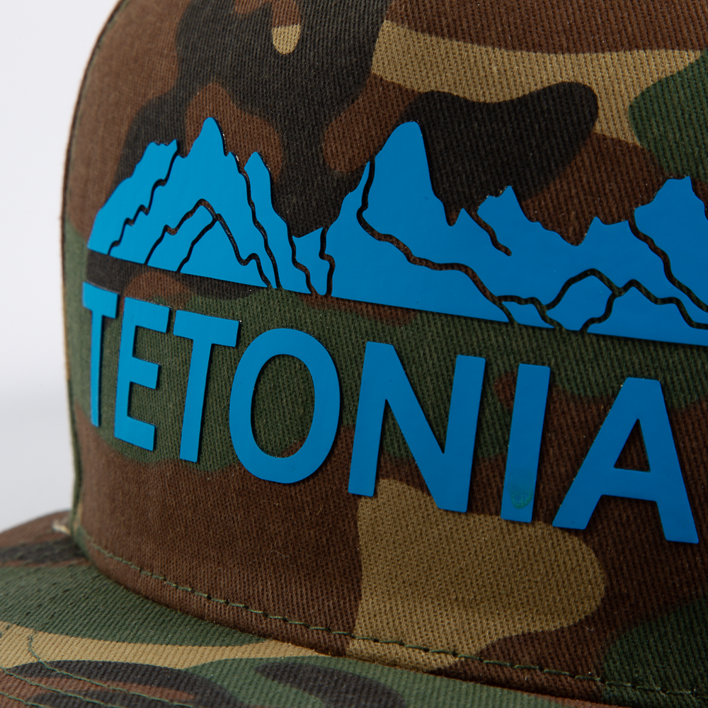 PAKO DESIGNS - TETONIAC® 5 PANEL FLAT BILL TWILL TRUCKER HAT - WOODLAND CAMO / MALIBU BLUE SILICONE