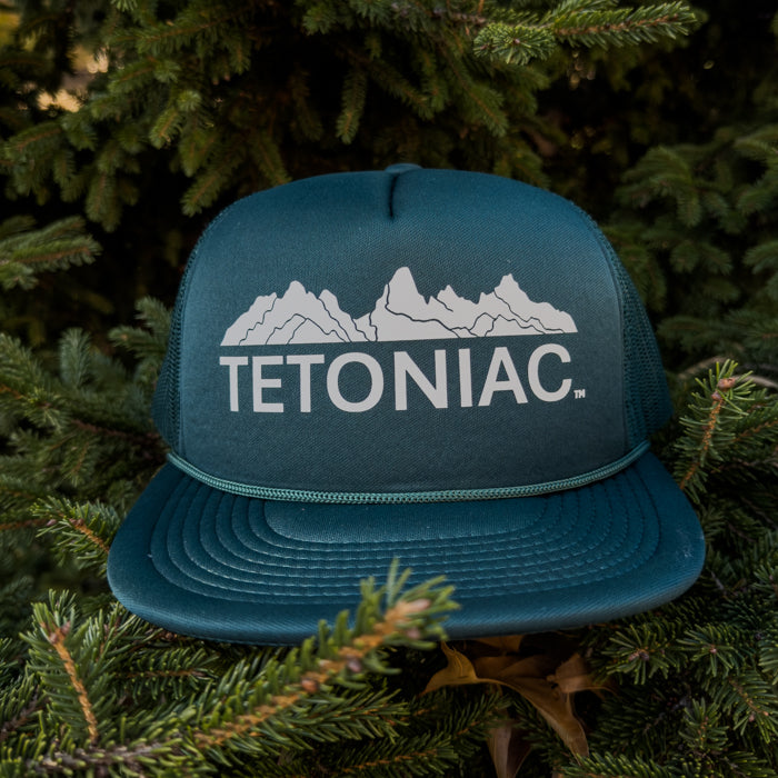 FOREST GREEN cap with 'TETONIAC' logo on a green leafy background