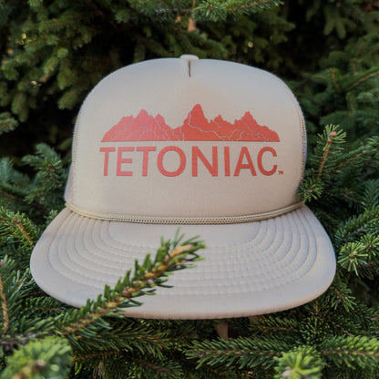 Beige cap with 'TETONIAC' logo on a green foliage background