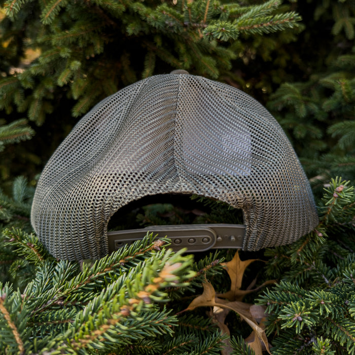 Gray mesh cap on a bed of green pine needles