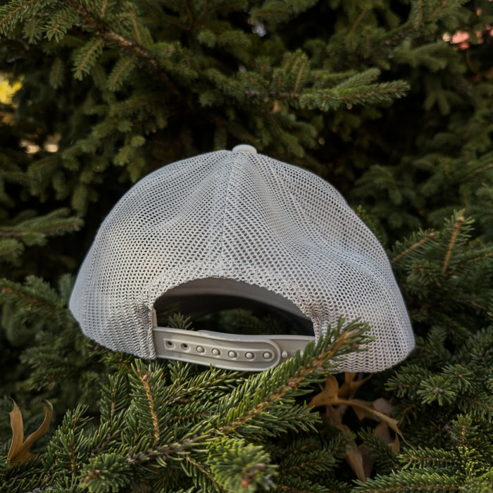 LIGHT GREY mesh cap on a background of green foliage